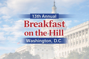 Text reading "13th Annual Breakfast on the Hill, Washington, D.C." is overlaid on a blurred image of the U.S. Capitol building against a partly cloudy sky.